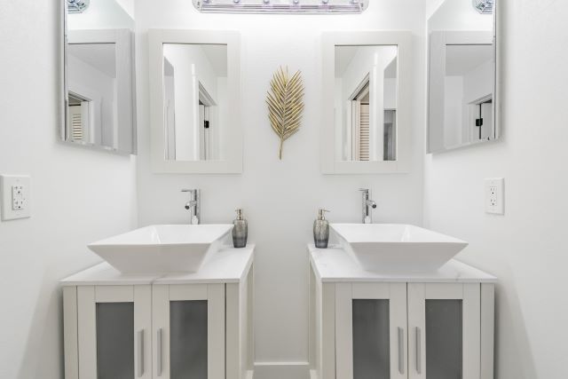 a bathroom with white sinks and mirrors