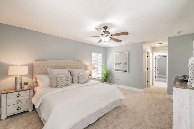 a bedroom with a ceiling fan and a bed