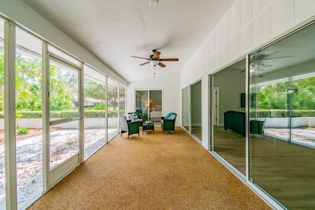 a room with glass doors and a ceiling fan